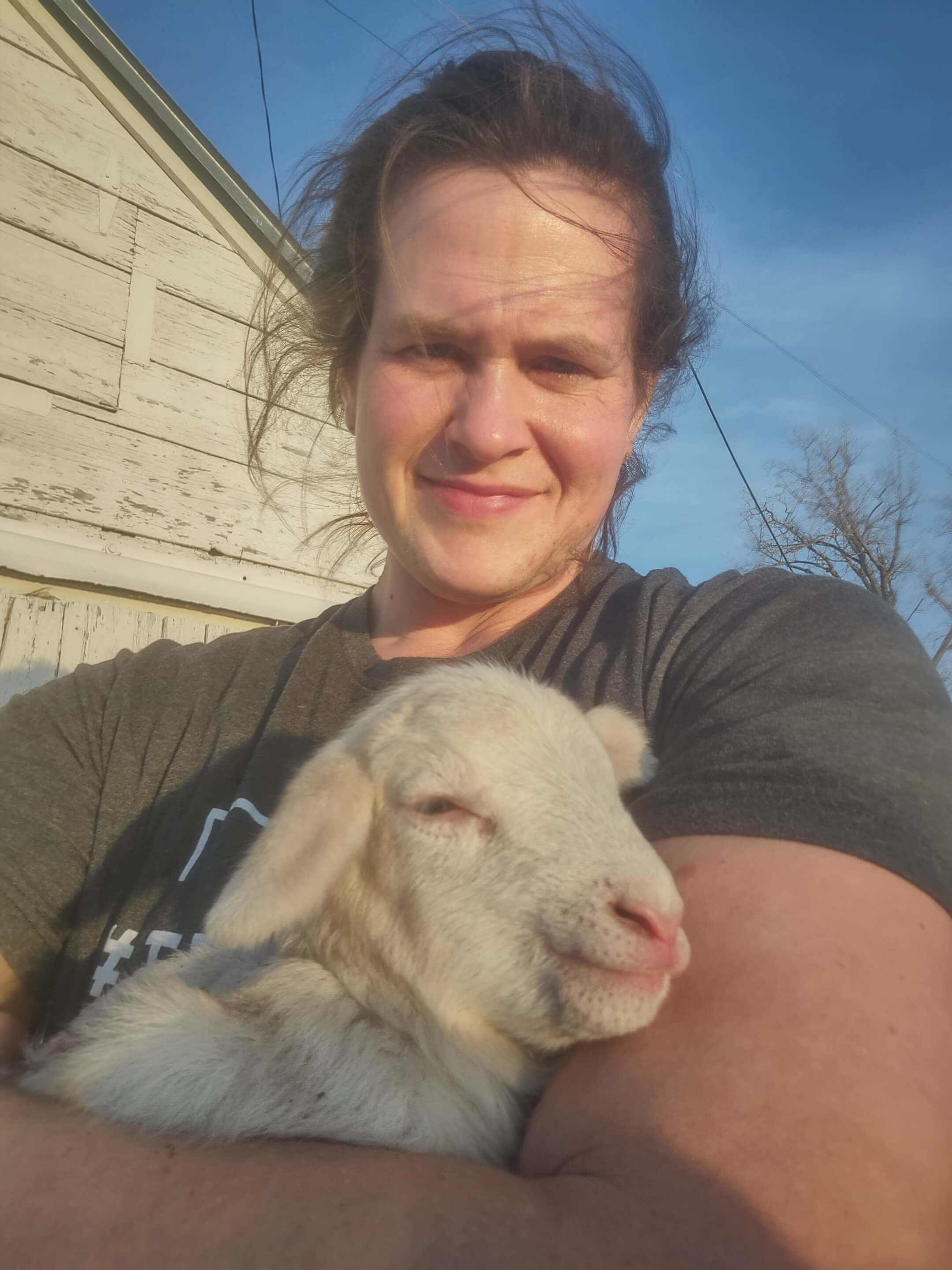 Payne Creek Acres owner holding a lamb
